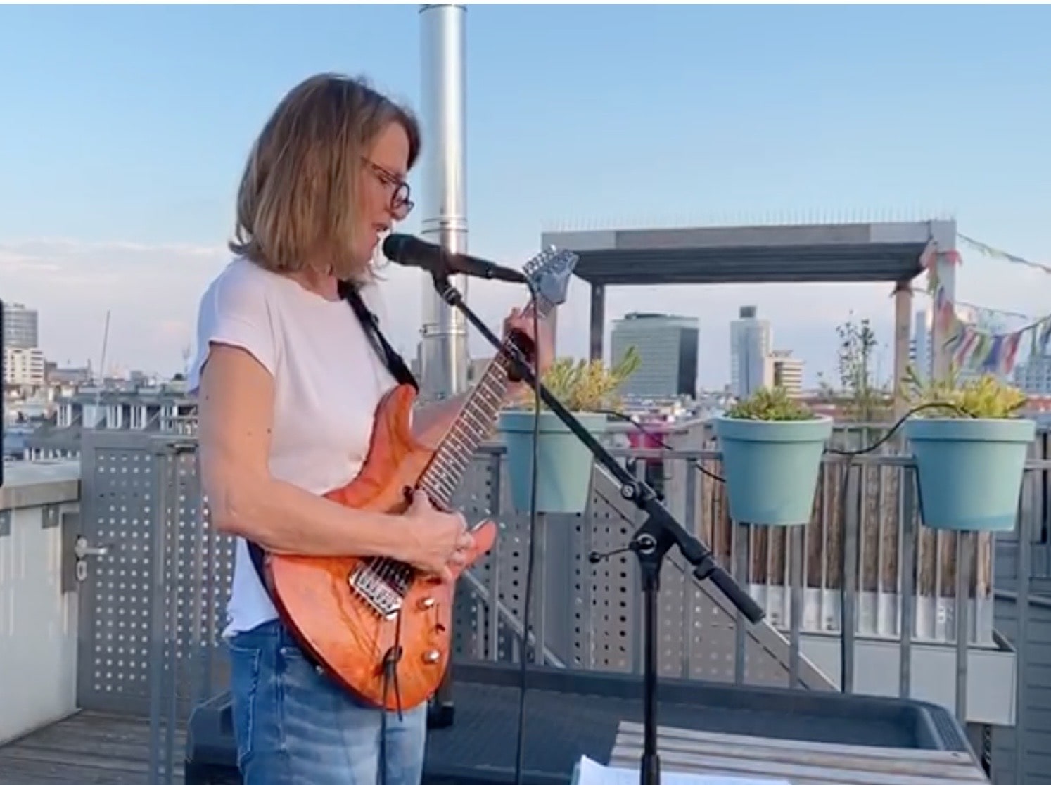 Doris mit Gitarre auf Dachterrasse.