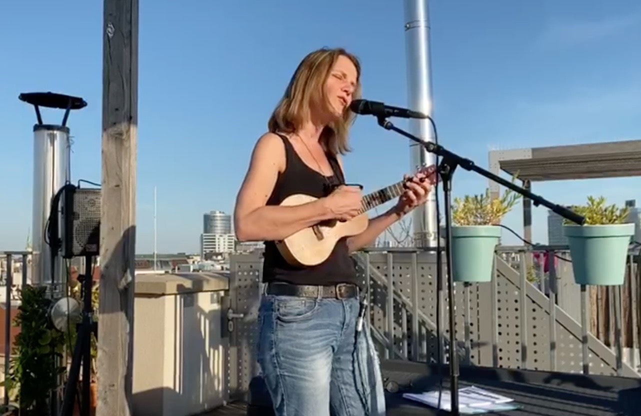 Ukulelespielend auf Dachterasse.