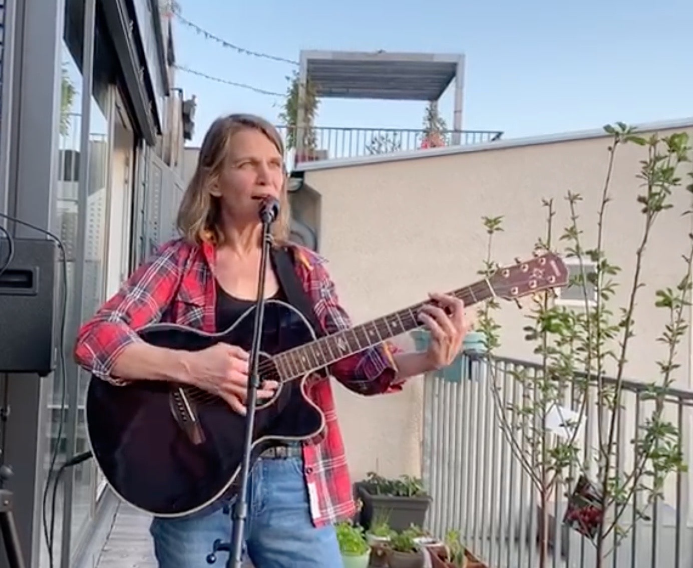 Gitarrespielend auf Balkon.