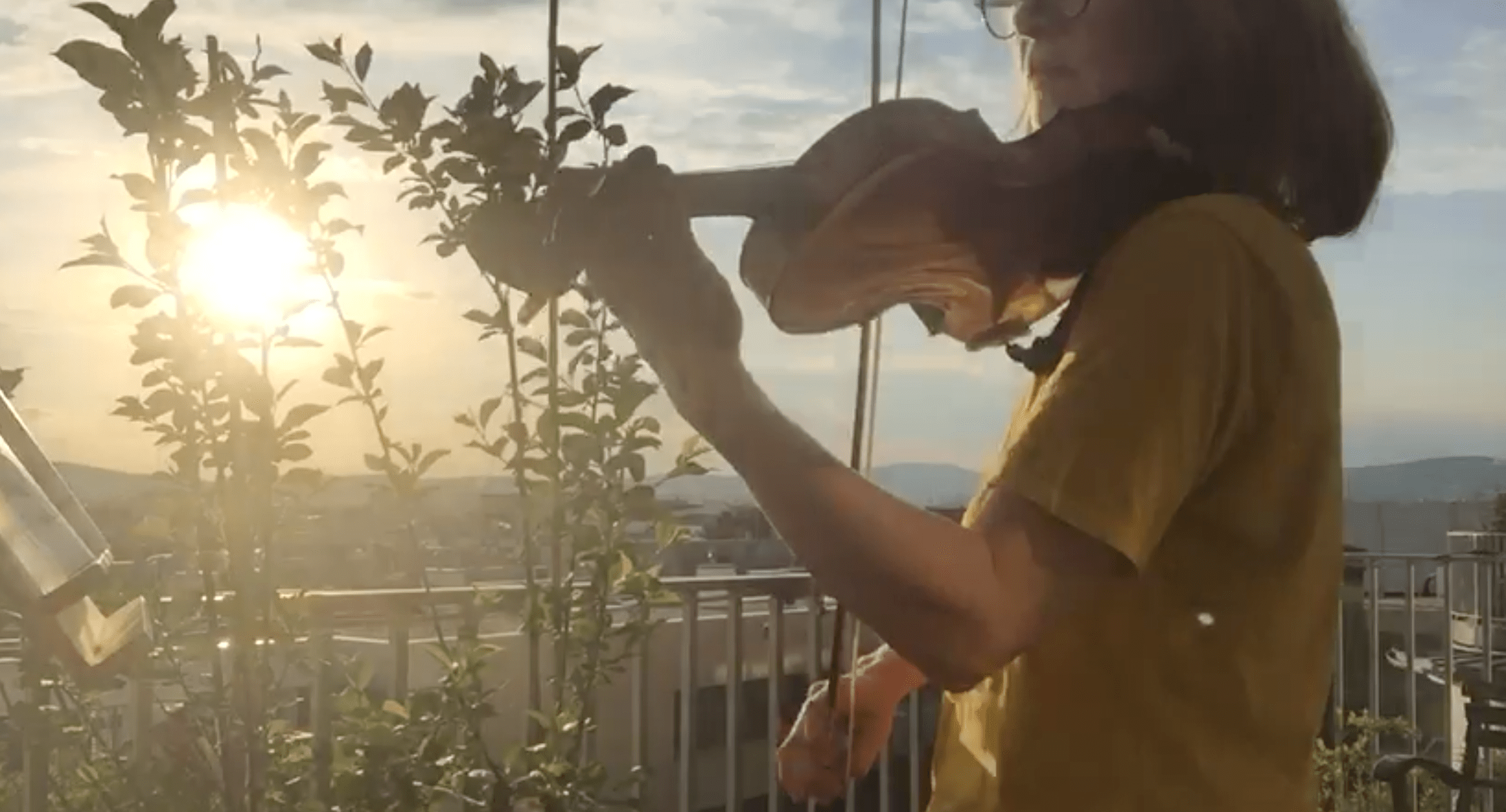 Doris spielt Geige auf einem Balkon.
